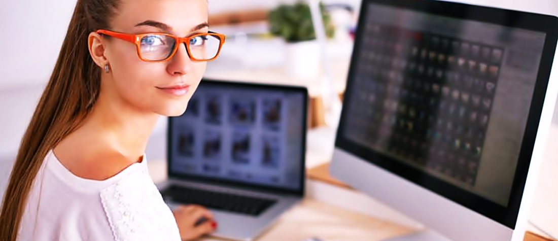 Nuna mujer de lentes voltea a ver a la cámara mientras está en un escritorio frente a una computadora 