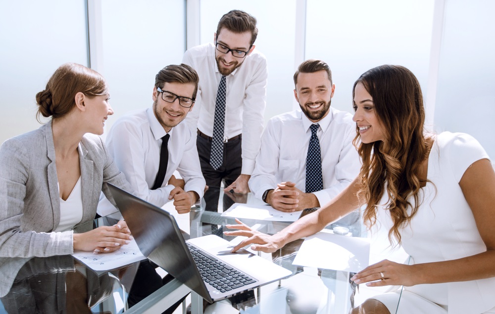 En una mesa de trabajo, varios ejecutivos de recursos humanos conversan en torno a  una computadora