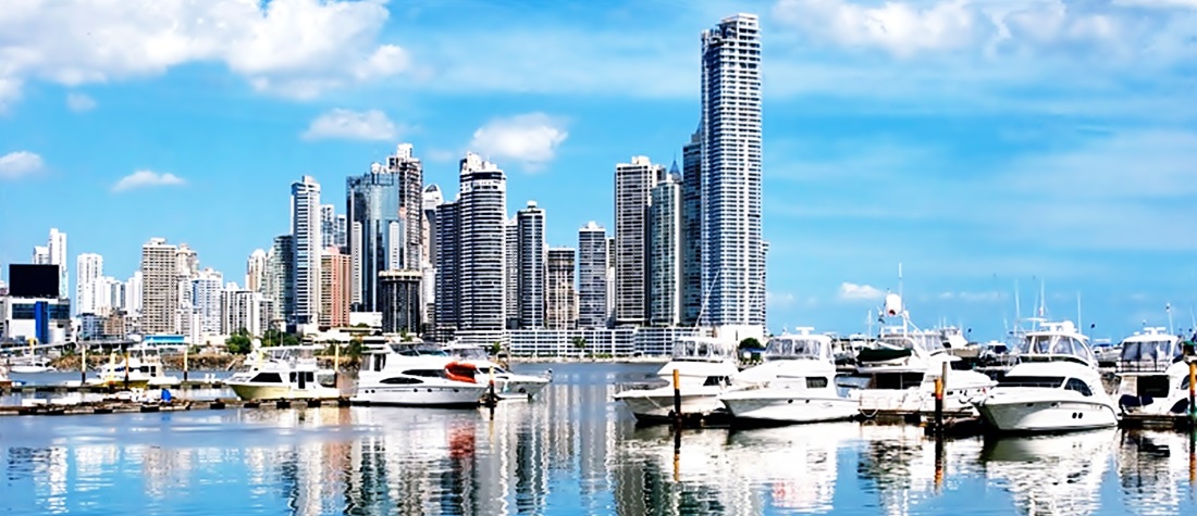 Vista del canal de Panamá, lanchas en un muelle con el fondo de edificios 